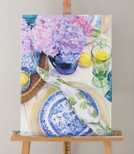 Load image into Gallery viewer, Elizabeth Alice Studio original acrylic painting art, blue willow dishes table setting with clear green glass goblet and lemons, blue glass vase with purple hydrangeas, blue and white vases, blue and white art painting, traditional art home decor, blue and purple painting, blue and white painting, art for blue and white home, grandmillennial art painting