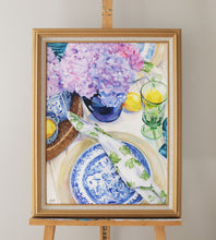 Load image into Gallery viewer, Elizabeth Alice Studio original acrylic painting art, blue willow dishes table setting with clear green glass goblet and lemons, blue glass vase with purple hydrangeas, blue and white vases, blue and white art painting, traditional art home decor, blue and purple painting, blue and white painting, art for blue and white home, grandmillennial art painting with gold frame