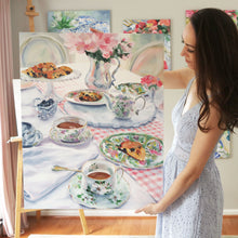 Load image into Gallery viewer, Elizabeth Alice Studio original painting, acrylic painting art, tea party scones table setting painting, art for dining room, loose brush strokes, modern updated traditional art decor, maryland artist, large original art for dining room, unique art for traditional home, pink and white painting. Magnolia Tea. Painting of tea cups, painting of tea set, painting of silverplate antiques. Artist holding the painting in studio. 
